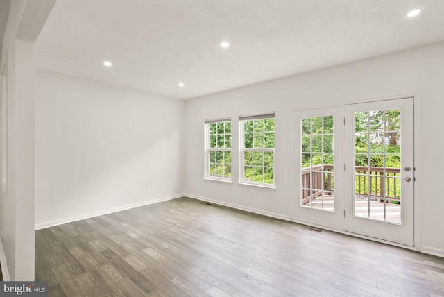 empty room with recessed lighting, wood finished floors, and baseboards