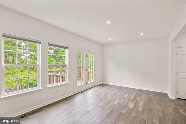 empty room featuring baseboards, wood finished floors, and recessed lighting