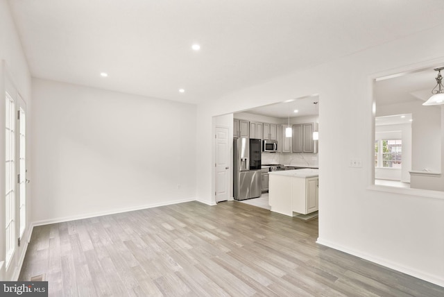 unfurnished living room with light wood-style floors, recessed lighting, and baseboards