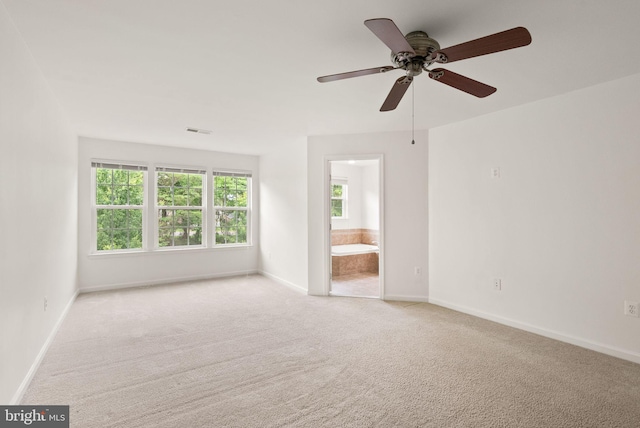 carpeted empty room featuring plenty of natural light, baseboards, and a ceiling fan