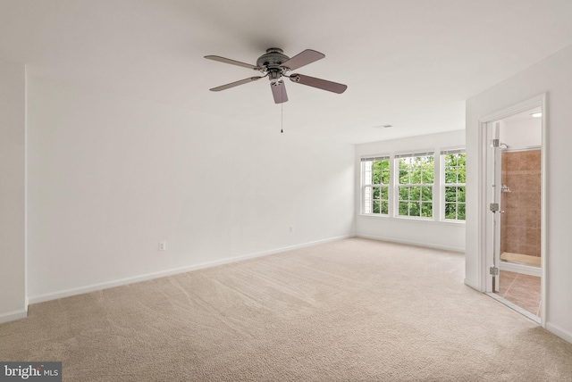 carpeted empty room featuring ceiling fan and baseboards