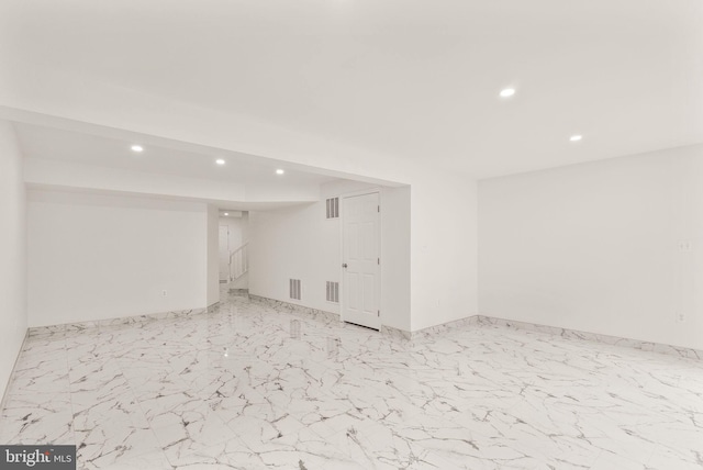 finished basement featuring recessed lighting, marble finish flooring, and stairway