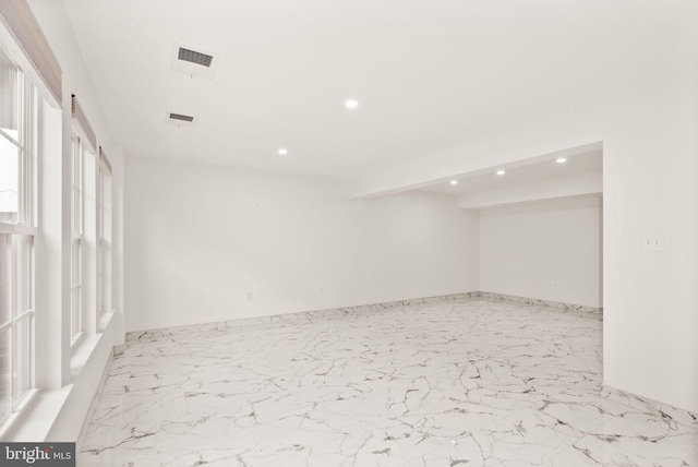spare room featuring recessed lighting and marble finish flooring