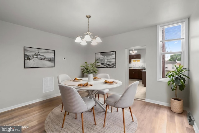 1307 Morling Ave, Baltimore, MD 21211 - dining space featuring a chandelier, light wood-style floors, and baseboards