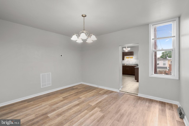1307 Morling Ave, Baltimore, MD 21211 - spare room with a chandelier, light wood-type flooring, baseboards, and a sink