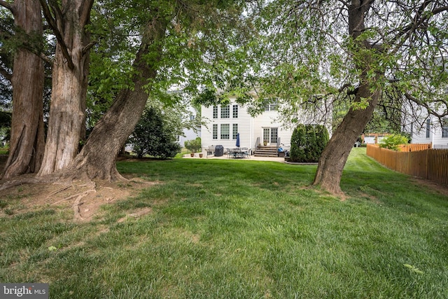 view of yard with fence, entry steps, and a patio area