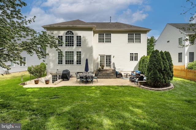 rear view of property featuring a yard, a patio, and fence