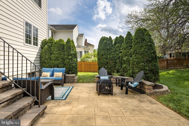 view of patio with an outdoor living space with a fire pit and fence
