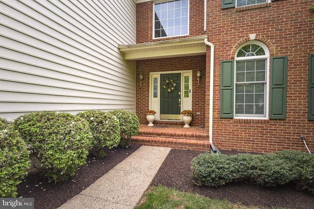 doorway to property with brick siding