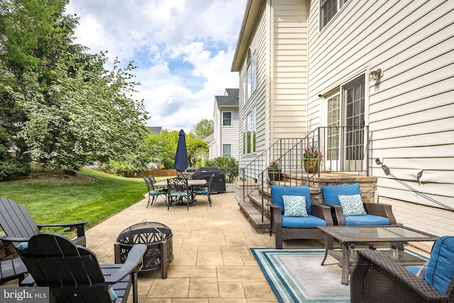 view of patio with outdoor dining space, grilling area, and a fire pit