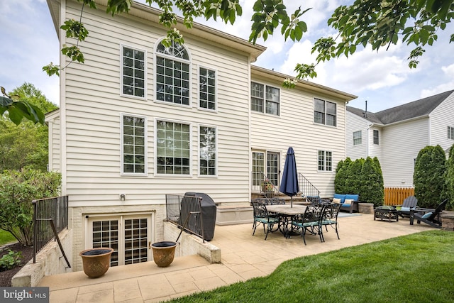 back of house featuring a yard, fence, a patio, and an outdoor living space with a fire pit