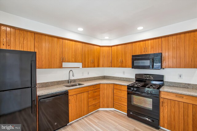 kitchen with black appliances, a sink, brown cabinetry, recessed lighting, and light countertops