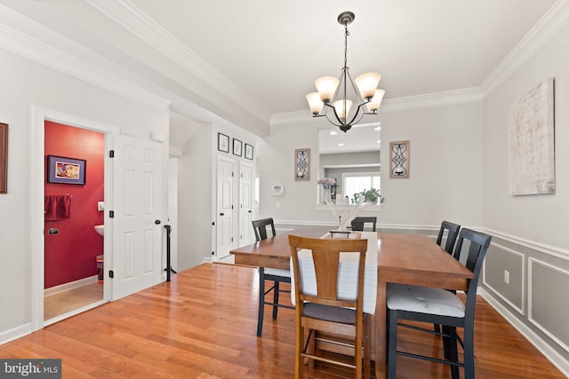 dining room with crown molding, a chandelier, and wood finished floors