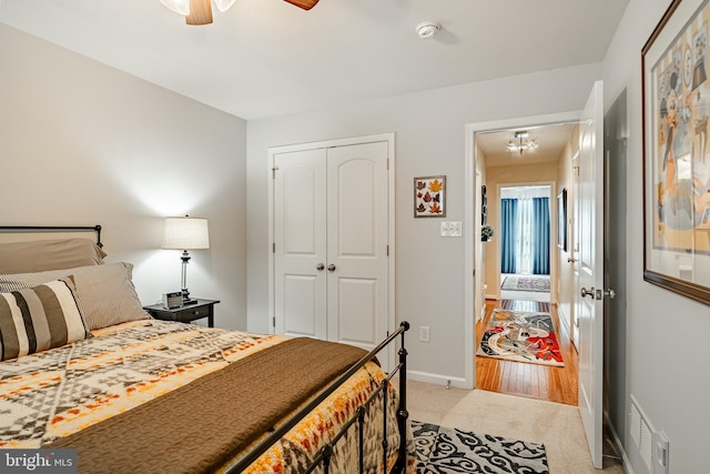 bedroom with light carpet, baseboards, a closet, and a ceiling fan