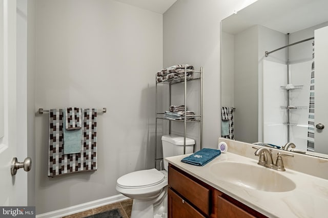 full bath featuring toilet, baseboards, vanity, and tile patterned flooring