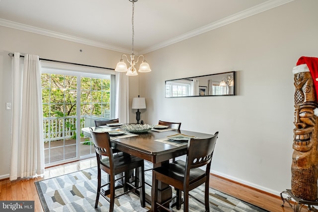 dining room with a chandelier, crown molding, light wood-style flooring, and baseboards