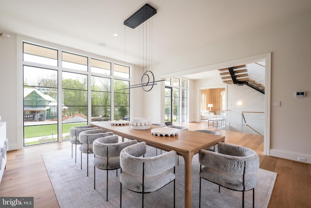 dining area with plenty of natural light, light wood-style flooring, and baseboards