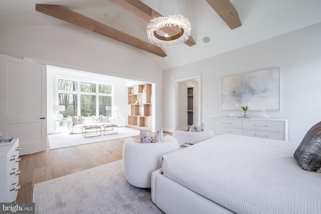 bedroom featuring a chandelier, high vaulted ceiling, wood finished floors, a spacious closet, and beam ceiling