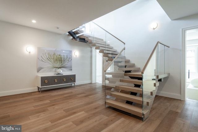 stairs with recessed lighting, baseboards, and wood finished floors