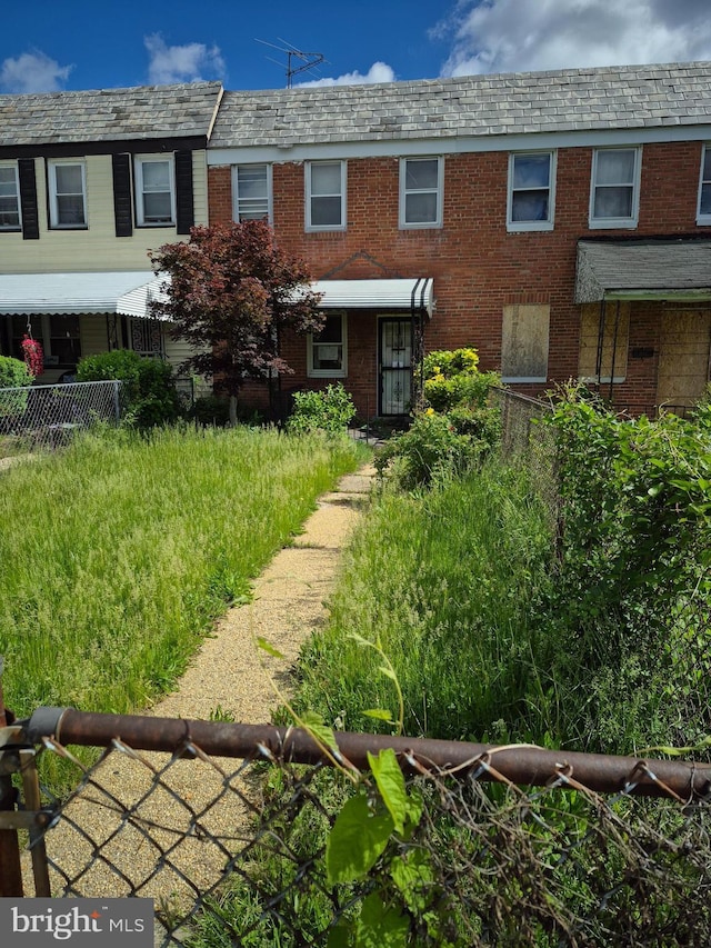 4929 Edgemere Ave, Baltimore, MD 21215 - view of front facade featuring brick siding, fence, a high end roof, and mansard roof