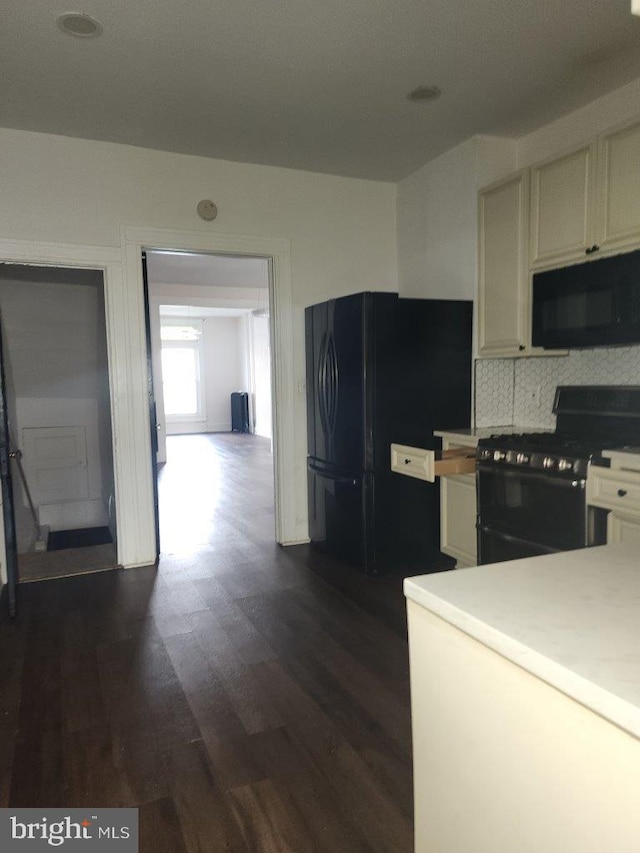 1018 N Bentalou St, Baltimore, MD 21216 - kitchen featuring white cabinets, dark wood-style flooring, black appliances, backsplash, and light countertops