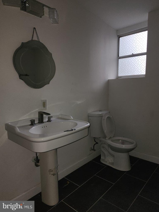 1018 N Bentalou St, Baltimore, MD 21216 - half bathroom with tile patterned flooring, toilet, and baseboards