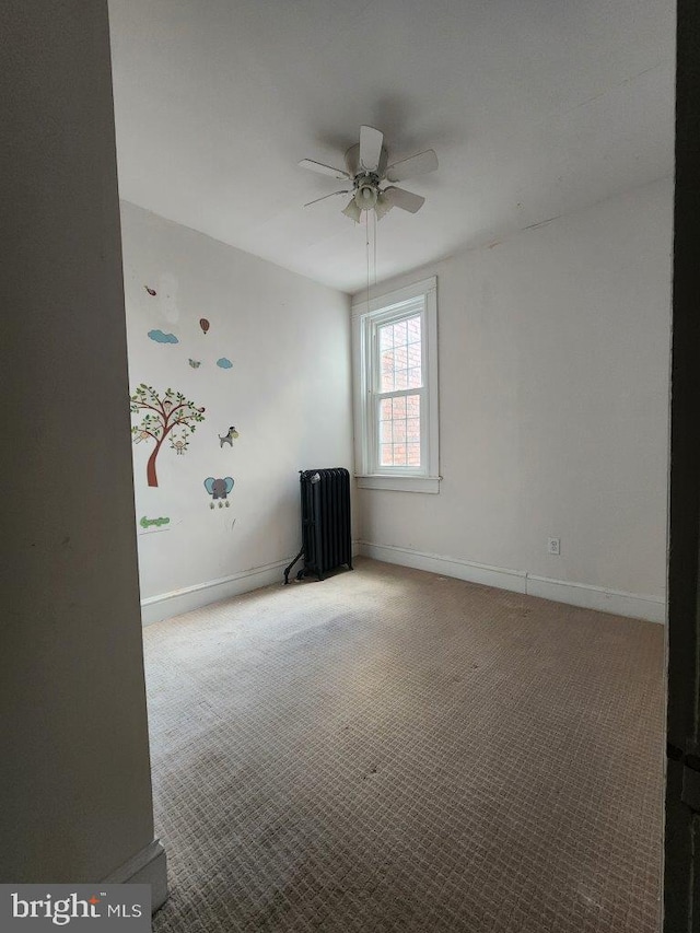 1018 N Bentalou St, Baltimore, MD 21216 - spare room featuring carpet floors, baseboards, a ceiling fan, and radiator heating unit