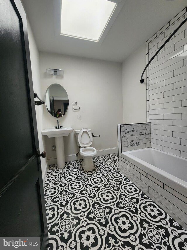 1018 N Bentalou St, Baltimore, MD 21216 - full bath with tiled shower / bath combo, toilet, tile patterned flooring, and baseboards