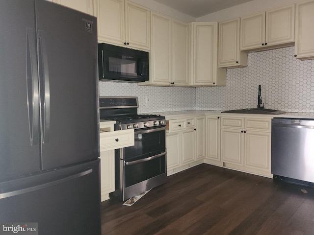 1018 N Bentalou St, Baltimore, MD 21216 - kitchen featuring stainless steel appliances, cream cabinets, dark wood-style floors, and a sink