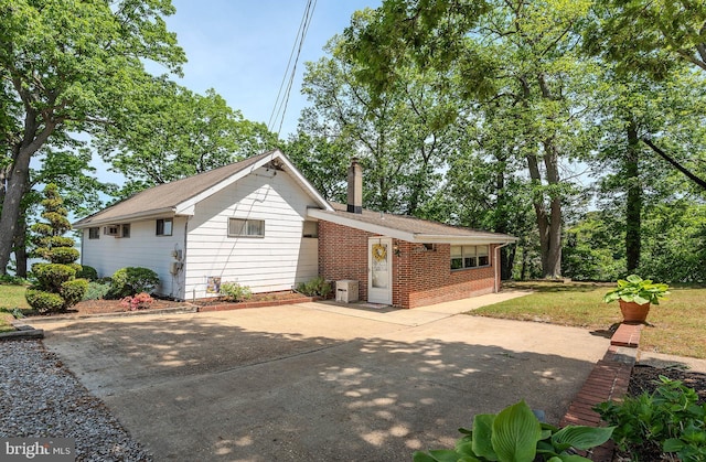 424 Alameda Pkwy, Arnold, MD 21012 - back of property featuring brick siding, a chimney, a patio, and concrete driveway