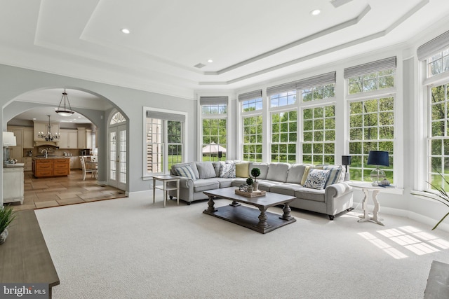 sunroom with arched walkways, french doors, and a notable chandelier