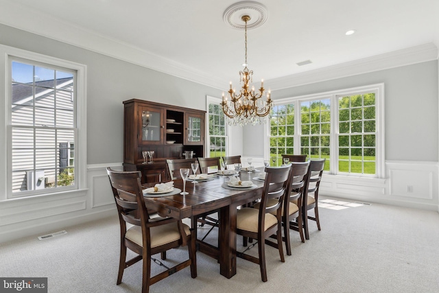 dining space featuring a wainscoted wall, a chandelier, visible vents, and light colored carpet