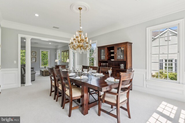 dining space with ornamental molding, light carpet, and a wainscoted wall