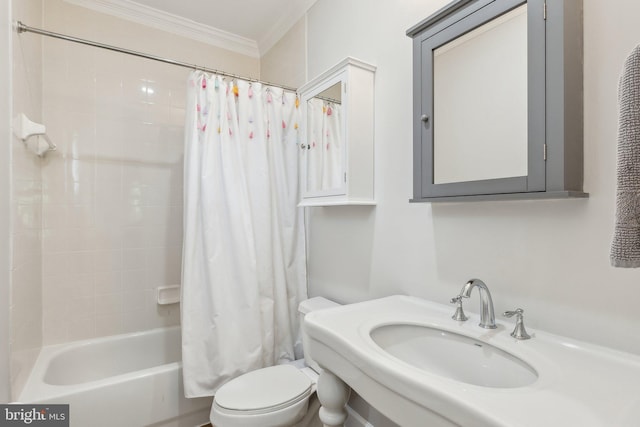 bathroom with a sink, ornamental molding, shower / bath combo with shower curtain, and toilet