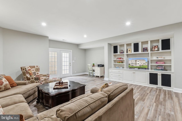 living room featuring baseboards, light wood-style floors, visible vents, and recessed lighting