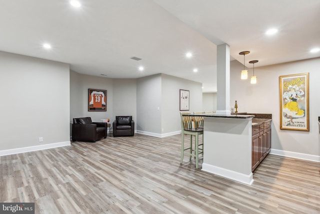 kitchen featuring light wood-style flooring, open floor plan, baseboards, and recessed lighting