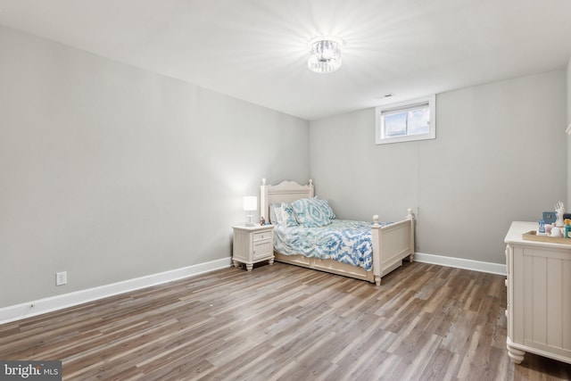 bedroom with baseboards and wood finished floors