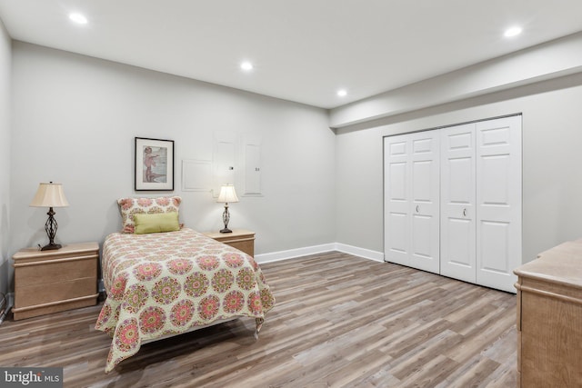 bedroom featuring baseboards, a closet, light wood finished floors, and recessed lighting
