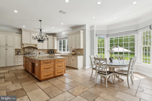 kitchen featuring baseboards, a wealth of natural light, ornamental molding, and tasteful backsplash