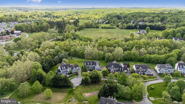 drone / aerial view featuring a wooded view and a residential view