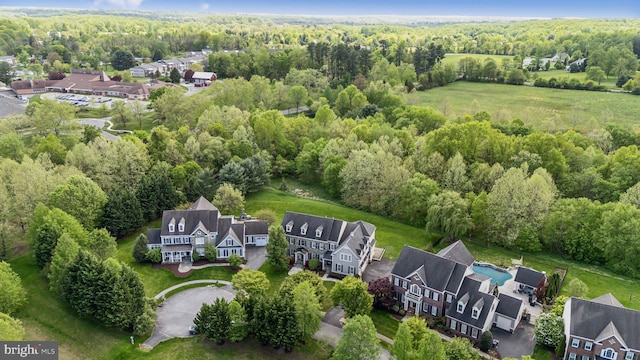 drone / aerial view with a wooded view and a residential view