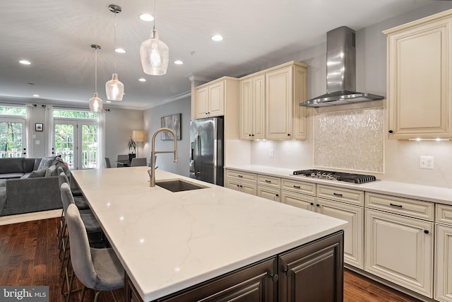 138 Merrimack Way, Arnold, MD 21012 - kitchen with cream cabinetry, wall chimney range hood, stainless steel appliances, a sink, and open floor plan
