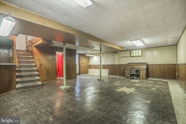 7423 Phelps Rd, Hanover, MD 21076 - basement with wood walls, tile patterned floors, a wood stove, and stairway