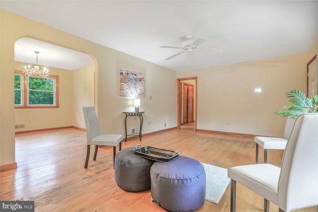 7423 Phelps Rd, Hanover, MD 21076 - living area featuring a ceiling fan, arched walkways, light wood-style flooring, a chandelier, and baseboards