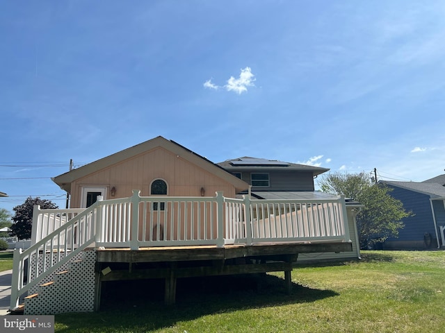 rear view of house with a yard and a deck