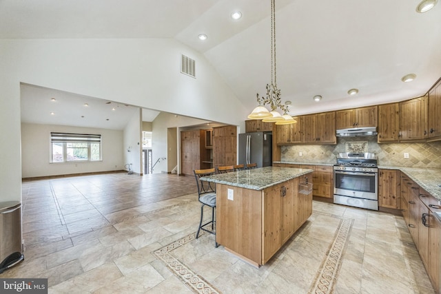 809 W 3rd Ave, Runnemede, NJ 08078 - kitchen featuring appliances with stainless steel finishes, under cabinet range hood, a center island, light stone counters, and high vaulted ceiling