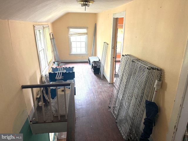 corridor with lofted ceiling, baseboards, and wood finished floors
