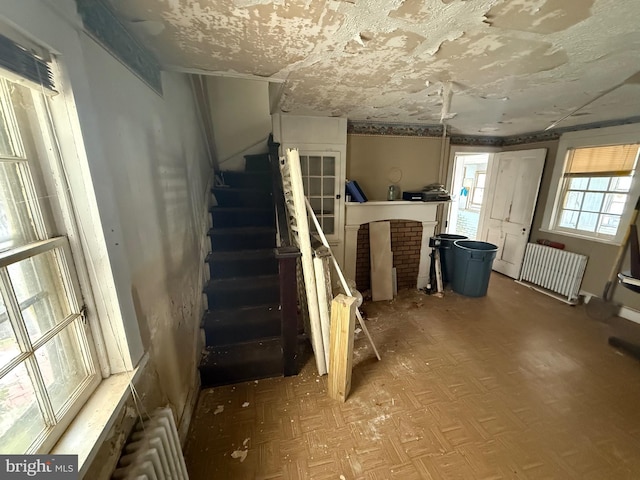 basement featuring radiator and stairs