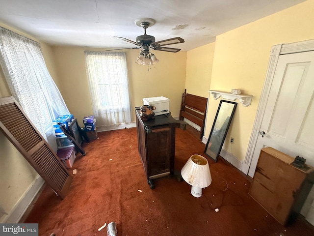 office featuring ceiling fan, dark colored carpet, and baseboards