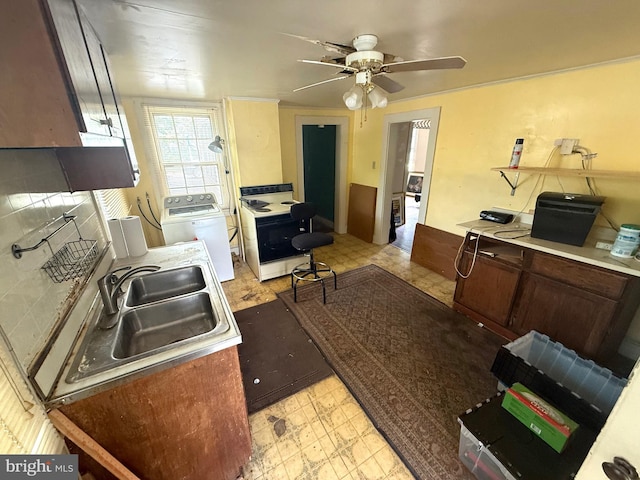 kitchen featuring a sink, washer / dryer, light floors, a ceiling fan, and white range with electric stovetop